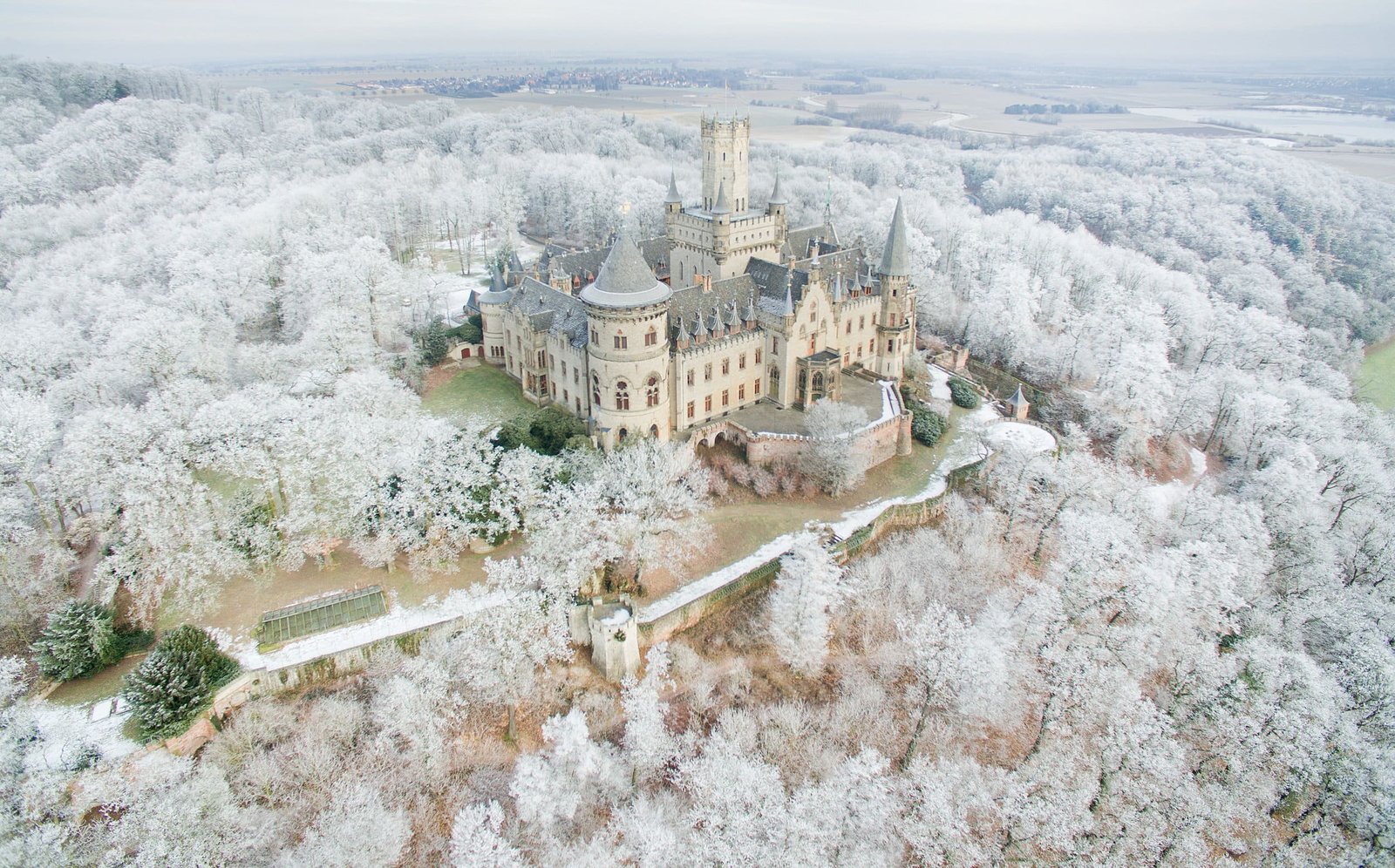 Die Luftaufnahme mit einer Drohne vom 18.01.2017 zeigt das Schloss Marienburg inmitten der von Raureif bedeckten Bäume bei Pattensen in der Region Hannover (Niedersachsen). Die im neugotischen Stil erbaute Residenz südlich von Hannover ist noch nahezu in dem Zustand, wie sie König Georg V. und seine Familie vor etwa 150 Jahren verlassen haben. Foto: Julian Stratenschulte/dpa | Verwendung weltweit