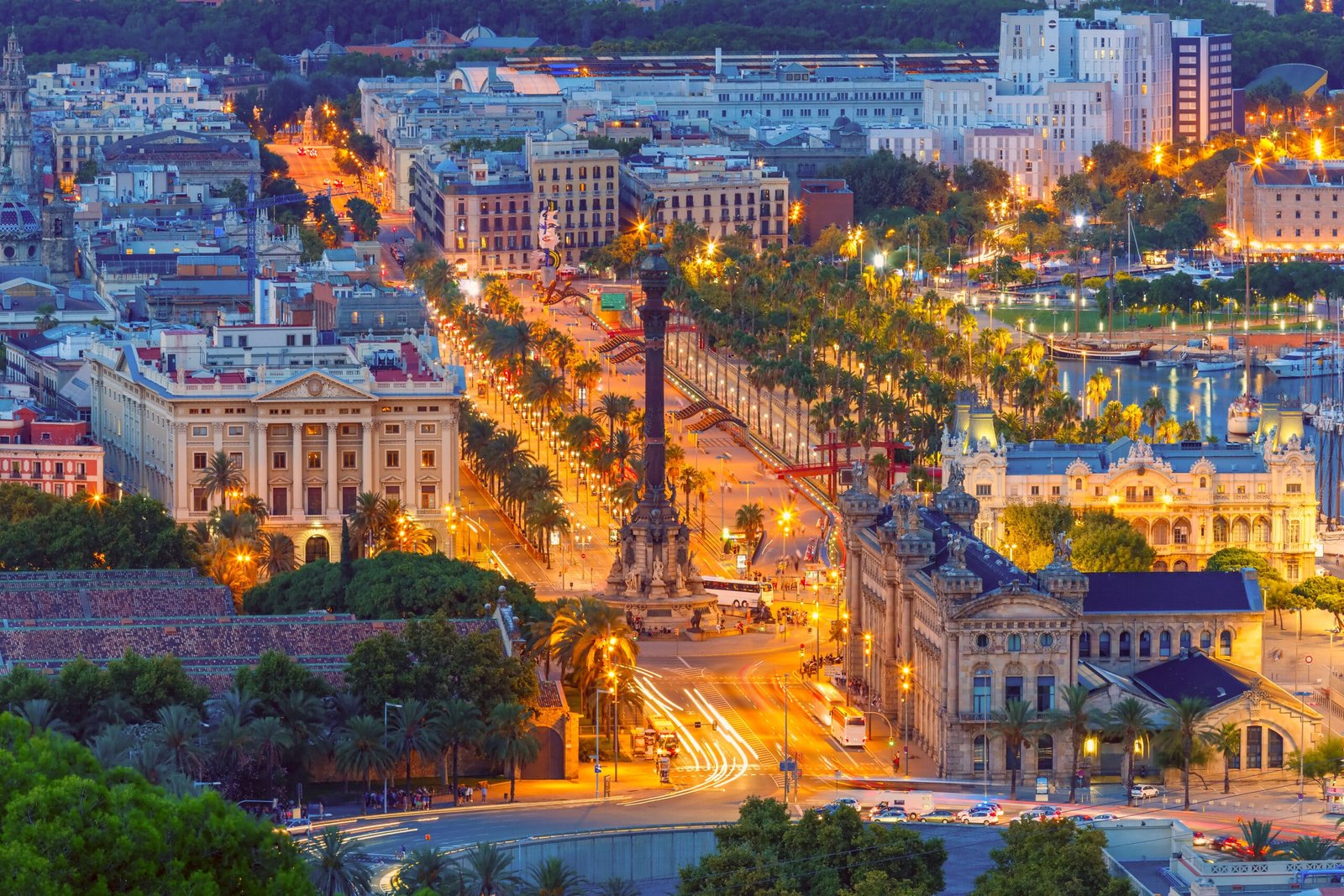 Aerial view over square Portal de la pau, and Port Vell marina and Columbus Monument at night in Barcelona, Catalonia, Spain